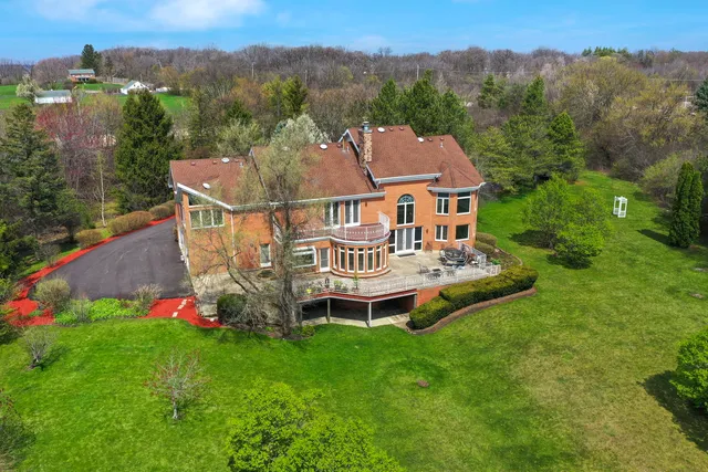 a view of a house with a big yard and large trees
