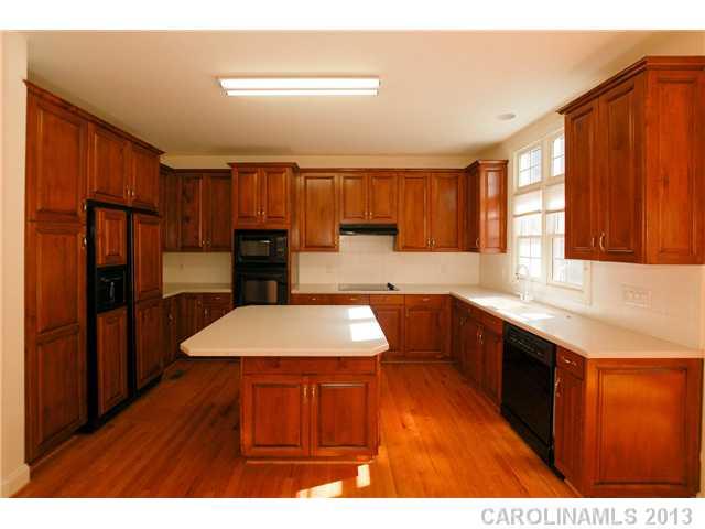 137 Sardis Pointe Road Matthews, NC 28105 - Photo 9 of 16 a kitchen with stainless steel appliances granite countertop a refrigerator a sink dishwasher and wooden cabinets with wooden floor