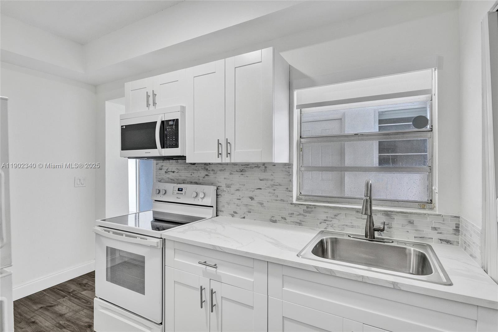 5750 Northwest 111th Street, Unit EFFICIENCY Hialeah, FL 33012 - Photo 5 of 27 a kitchen with white cabinets and a sink