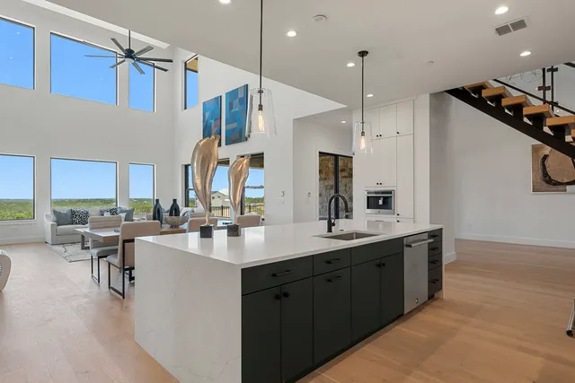 a kitchen with counter top space appliances and a view of living room