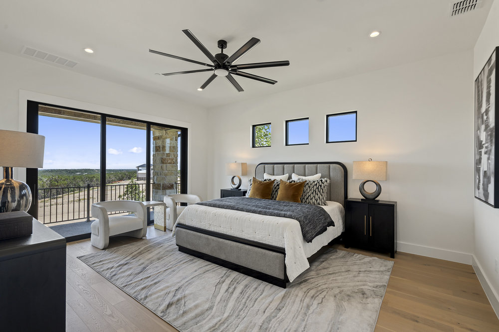6101 Adhara Pass Austin, TX 78730 - Photo 22 of 40 a spacious bedroom with a large bed and a chandelier