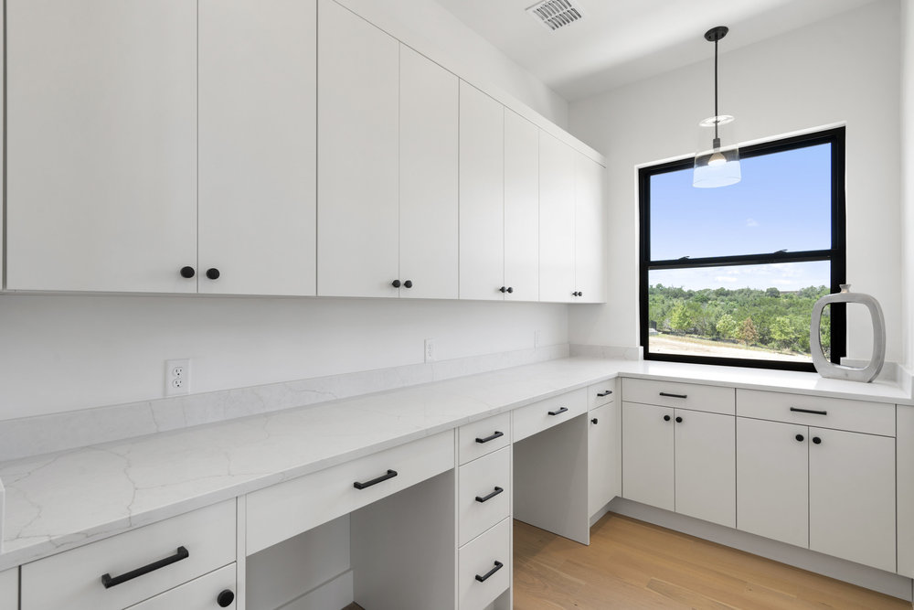 6101 Adhara Pass Austin, TX 78730 - Photo 24 of 40 a kitchen with granite countertop white cabinets white appliances and a wide window