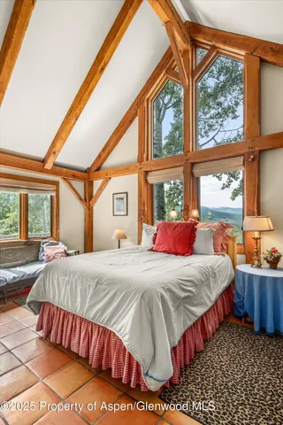 a bedroom with a bed a couch and large window