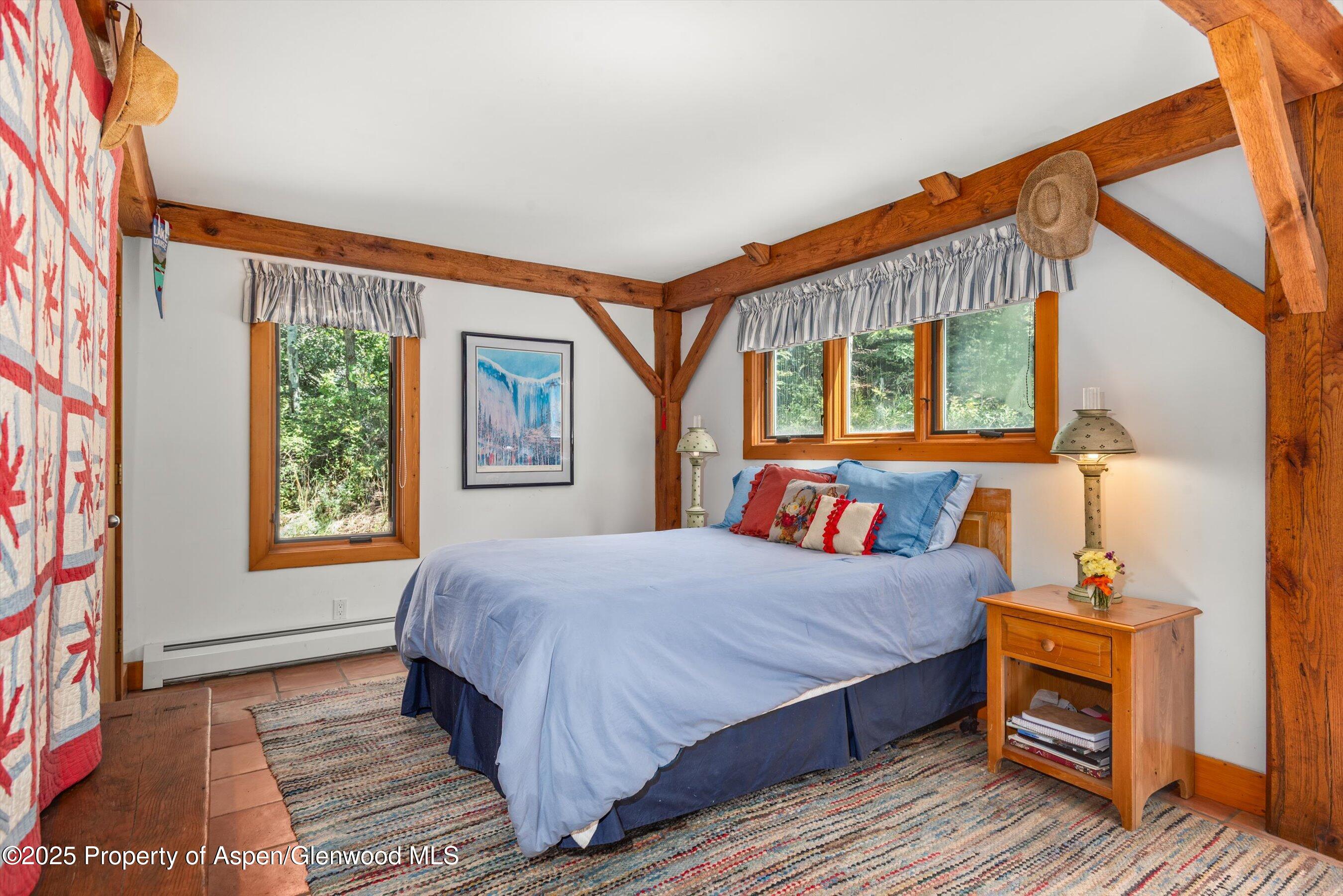 927 Red Mountain Road Aspen, CO 81612 - Photo 20 of 37 a bedroom with a bed a dresser next to a window
