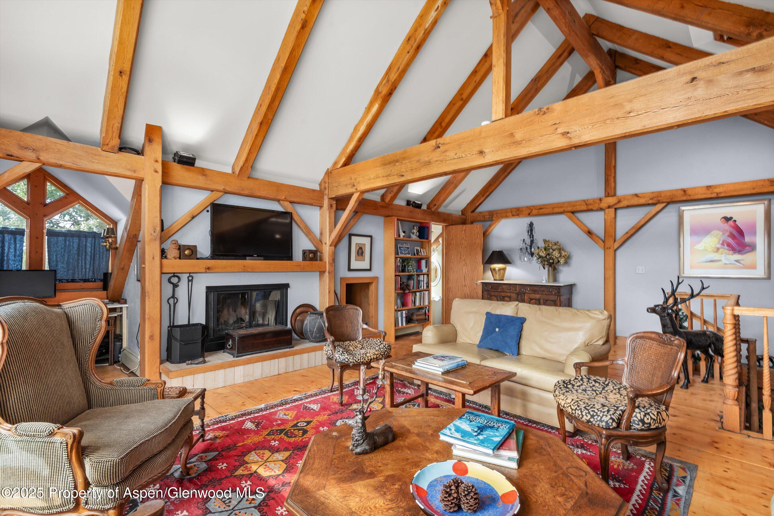 927 Red Mountain Road Aspen, CO 81612 - Photo 22 of 37 a living room with fireplace furniture and a floor to ceiling window