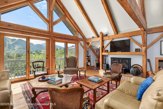 a living room with fireplace furniture and a large window