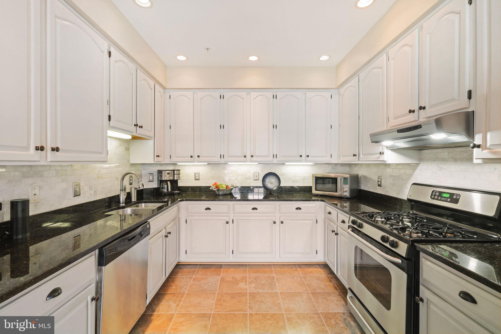 220 Thaxton Street Gaithersburg, MD 20878 - Photo 14 of 61 a large kitchen with granite countertop a stove sink and cabinets