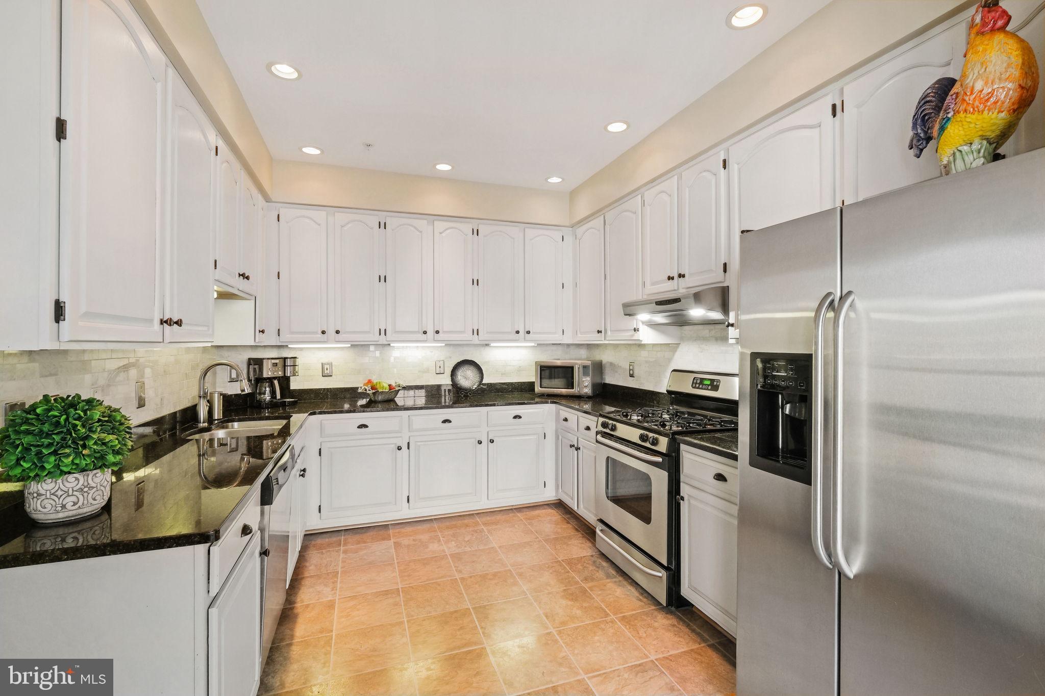 220 Thaxton Street Gaithersburg, MD 20878 - Photo 16 of 61 a kitchen with stainless steel appliances granite countertop a stove a sink and a refrigerator