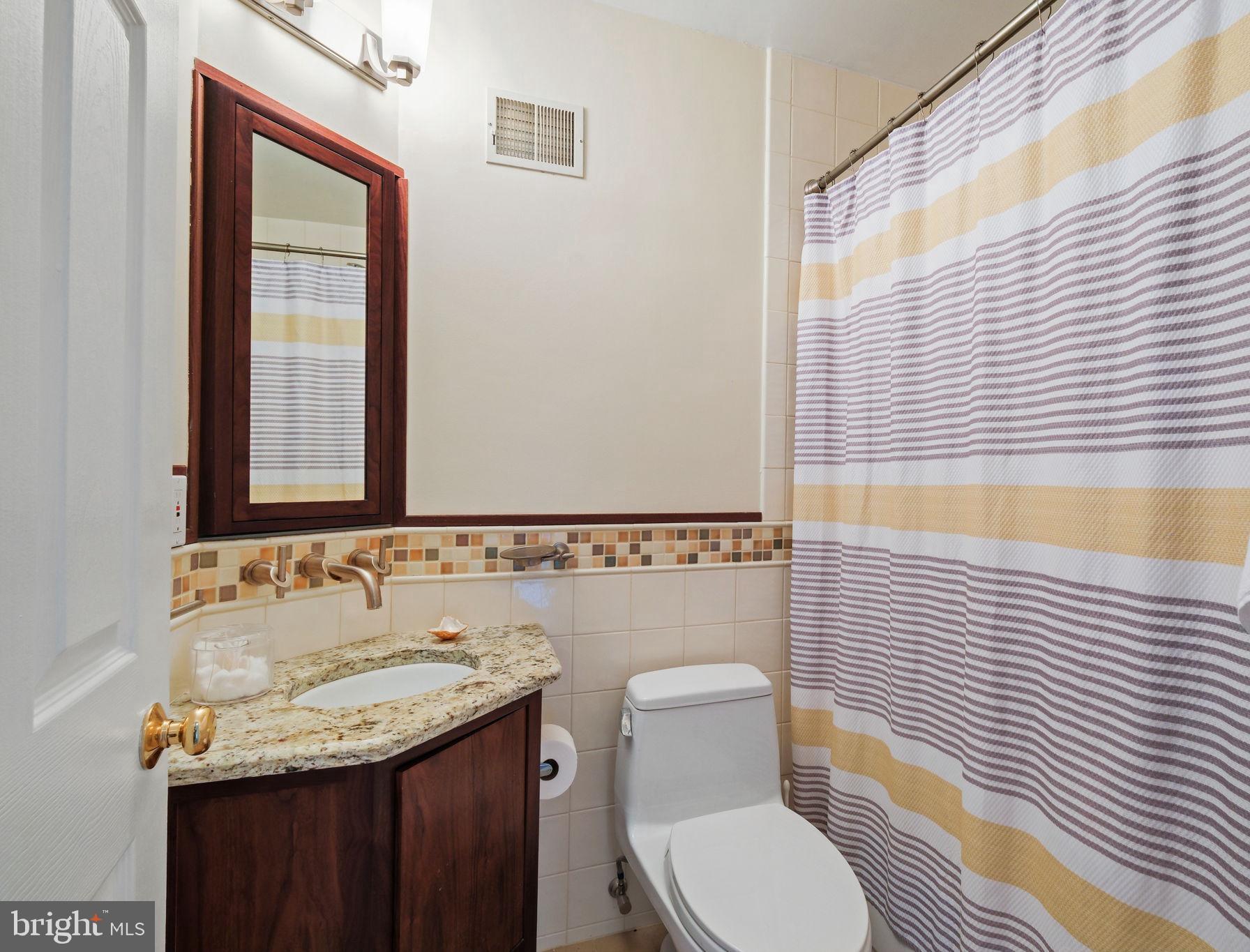 220 Thaxton Street Gaithersburg, MD 20878 - Photo 23 of 61 a bathroom with a granite countertop toilet a sink and a mirror