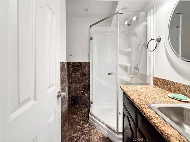 a bathroom with a granite countertop sink a toilet and shower