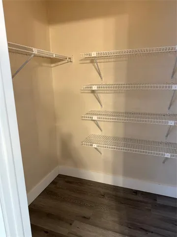 an empty room with wooden floor and cabinet