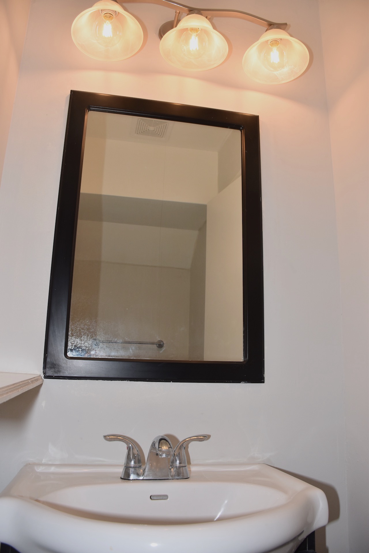 1810 Rawhide Loop Round Rock, TX 78681 - Photo 9 of 29 Pedestal sink with chrome faucet hardware, framed mirror, and a three-light vanity fixture