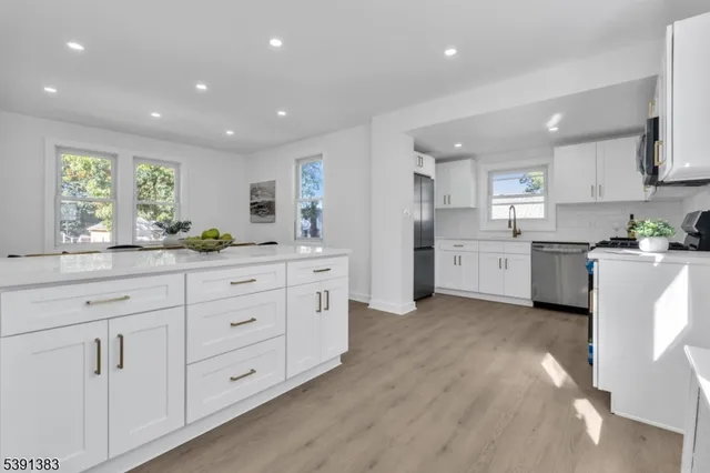 a kitchen with white cabinets and sink