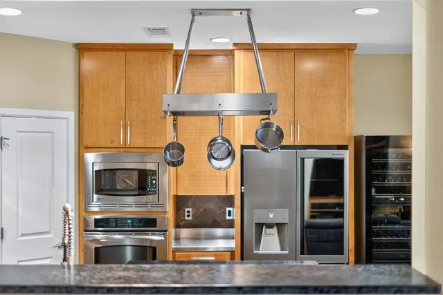 a kitchen with stainless steel appliances granite countertop a sink a stove and a wooden floors