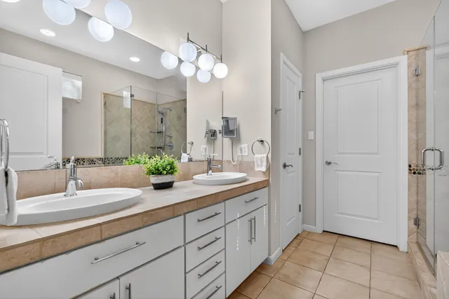 a bathroom with a double vanity sink a mirror and a shower