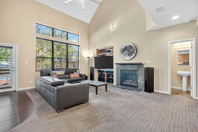 an empty room with windows fireplace and cabinet