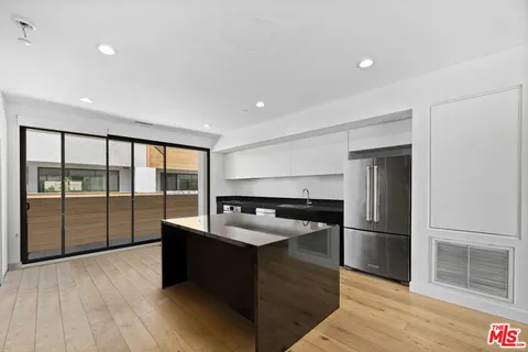 a kitchen with stainless steel appliances granite countertop a refrigerator and a sink