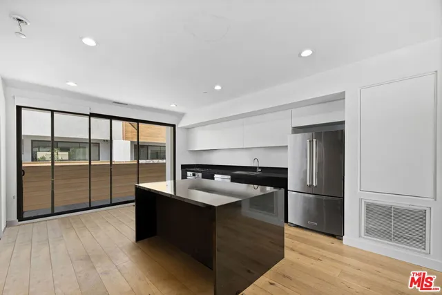 a kitchen with stainless steel appliances granite countertop a refrigerator and a sink