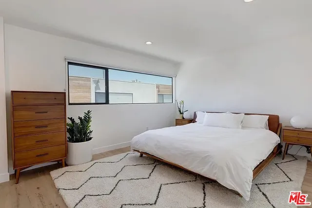 a bedroom with a bed and a potted plant