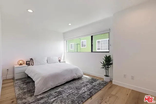 a bedroom with a bed and a potted plant