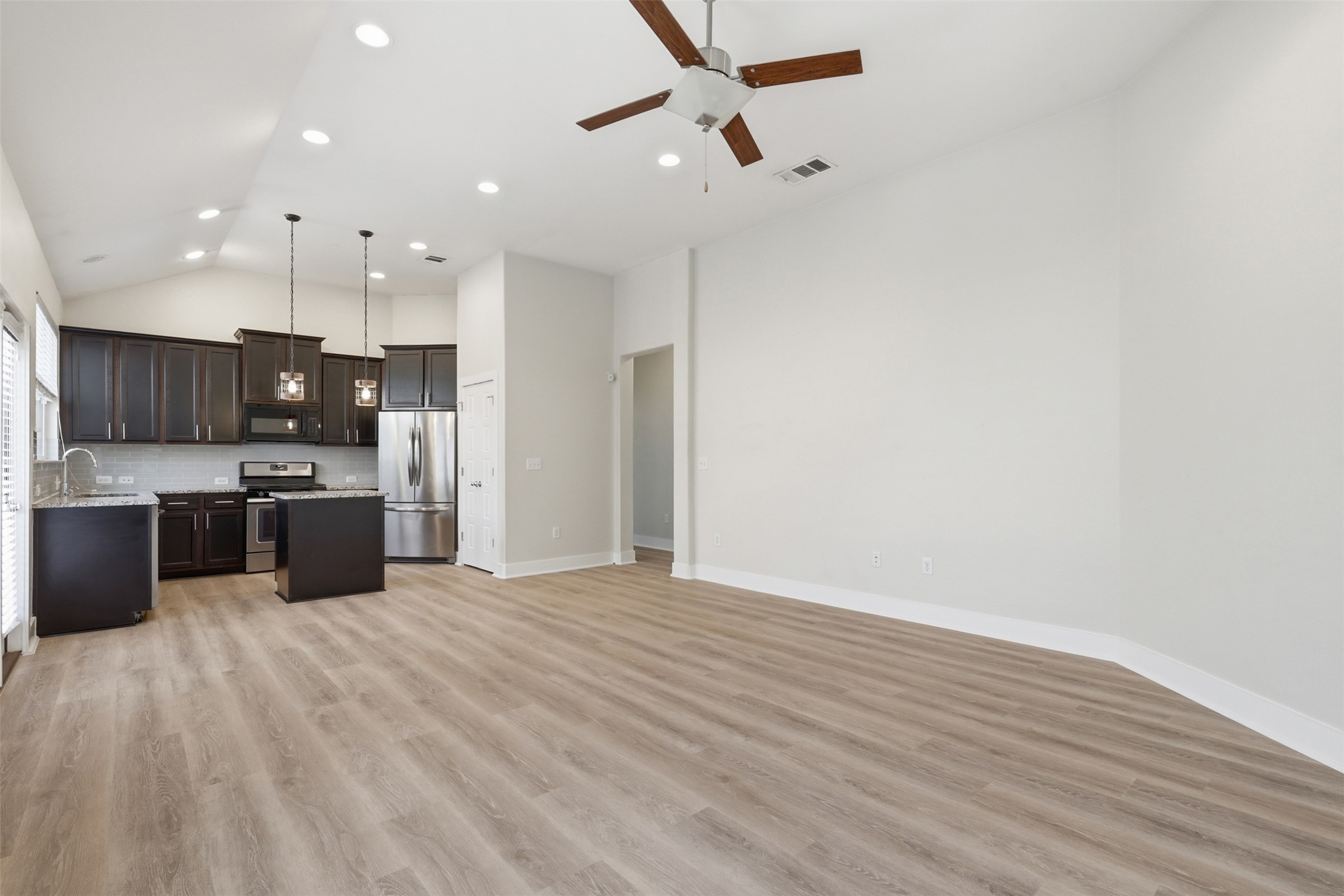 7208 Lysander Court Austin, TX 78741 - Photo 6 of 15 a large kitchen with stainless steel appliances a large counter top a stove and a refrigerator