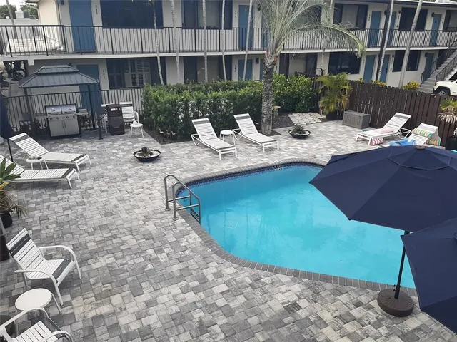 a view of a house with backyard water fountain and sitting area