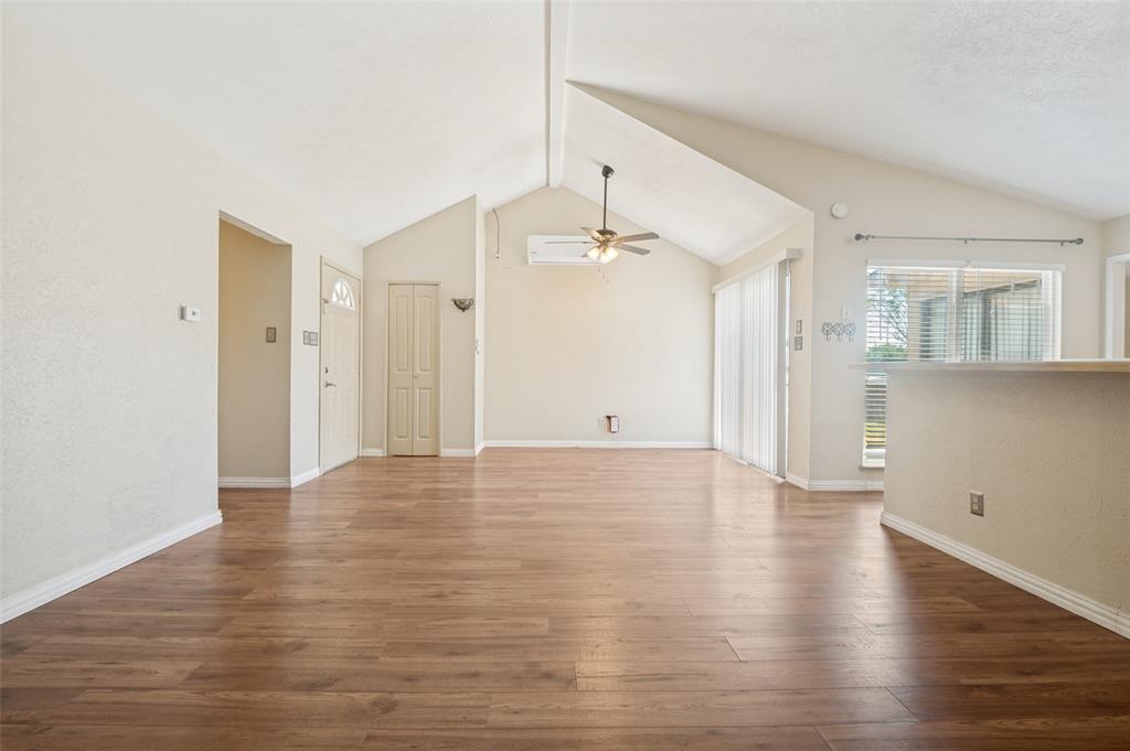 7305 Pineberry Road Dallas, TX 75249 - Photo 3 of 25 a view of an empty room with wooden floor and a window