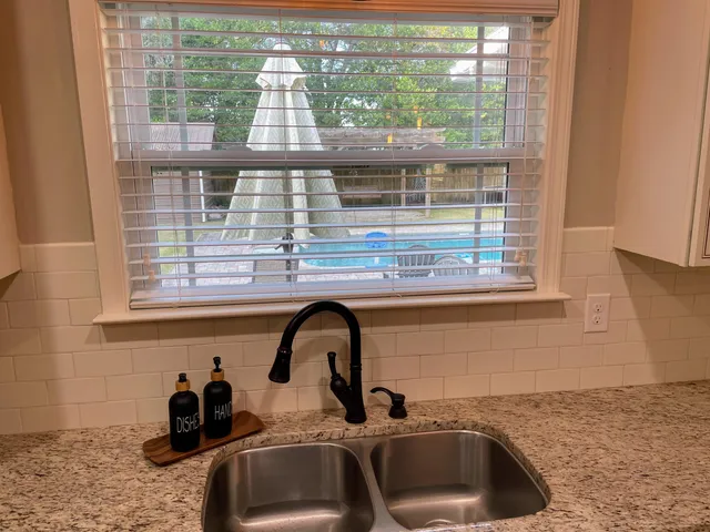 a kitchen with a sink a window and cabinets