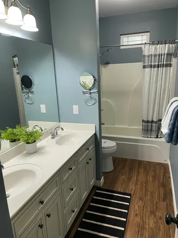 a bathroom with a sink a toilet and shower