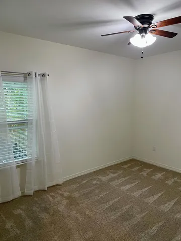 an empty room with fan and entrance
