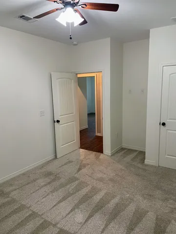 en empty room with windows and fan