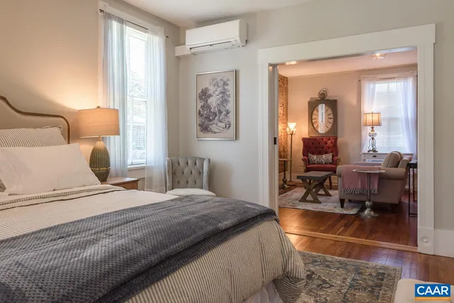 a bedroom with a bed a table and chair with the view of bathroom