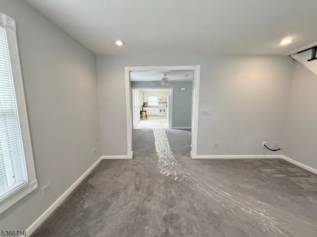 an empty room with a bathroom and a window