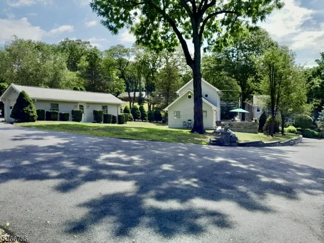 a view of a big house with large trees and plants