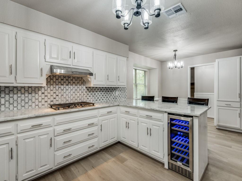 a kitchen with kitchen island granite countertop a white cabinets and chandelier