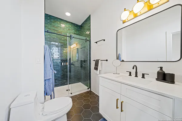 a bathroom with a double vanity sink toilet and shower