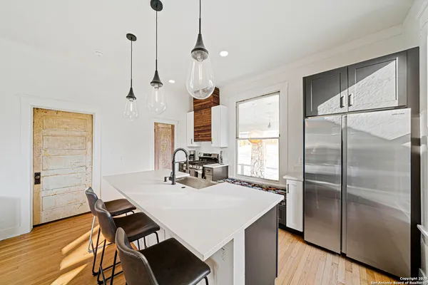 a kitchen with stainless steel appliances a table chairs and refrigerator