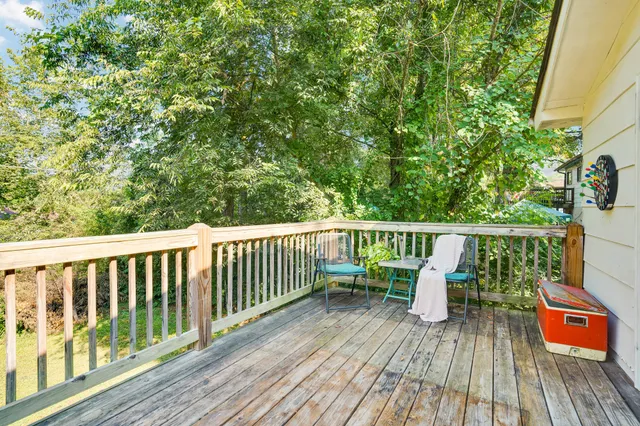 a balcony with wooden floor table and chairs