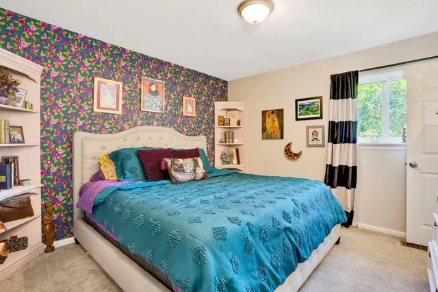 a bedroom with a bed window and wall painting
