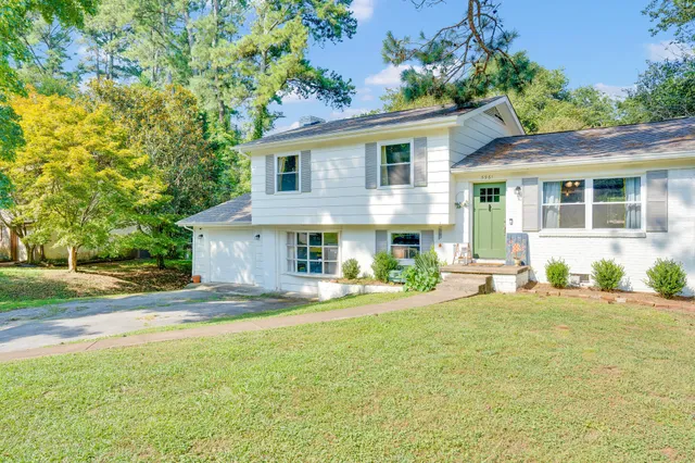 a view of a house with patio and a yard