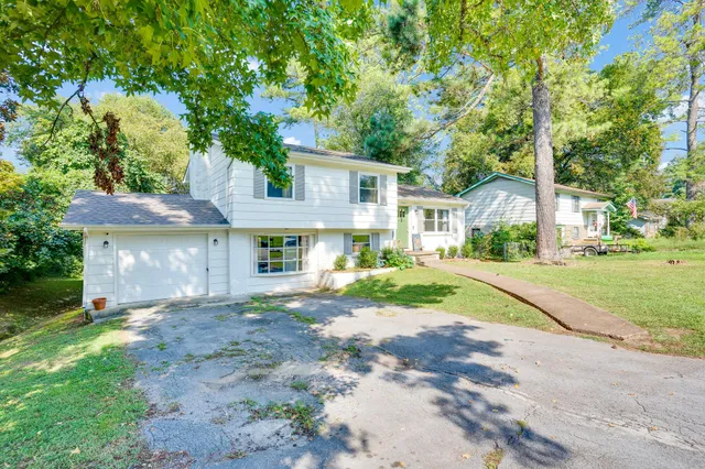 a front view of a house with a yard and trees