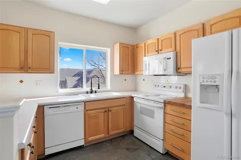 a kitchen with white cabinets and white appliances