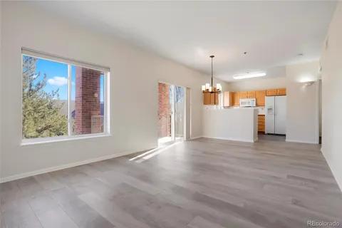 a view of a big room with wooden floor and windows