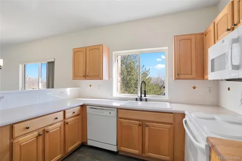 a kitchen with granite countertop a sink stainless steel appliances white cabinets and a granite counter tops