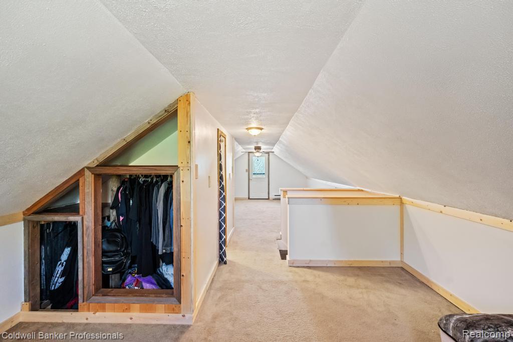 6389 Postlewait Road Mancelona, MI 49659 - Photo 35 of 50 Carpeted flooring, vaulted ceiling, built-in wooden shelving, and recessed lighting