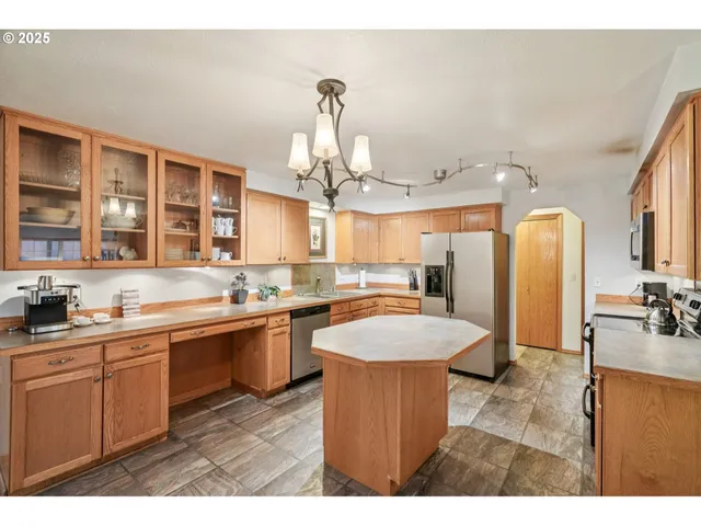 a large kitchen with kitchen island a sink stainless steel appliances and cabinets