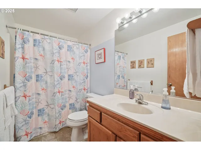 a bathroom with a granite countertop sink a toilet and a mirror