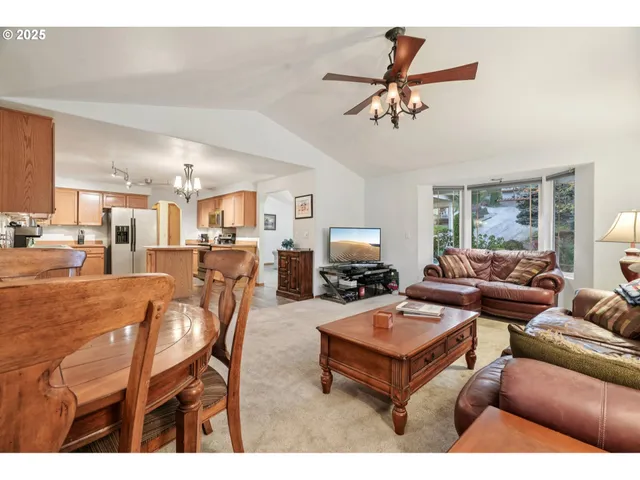 a living room with furniture kitchen view and a window
