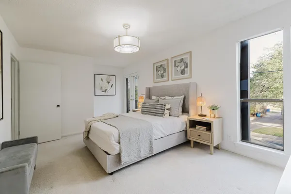a spacious bedroom with a bed and a window