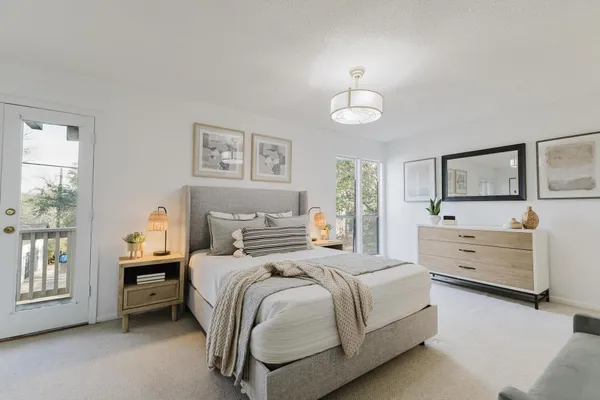 a bedroom with a bed a chandelier and a dresser